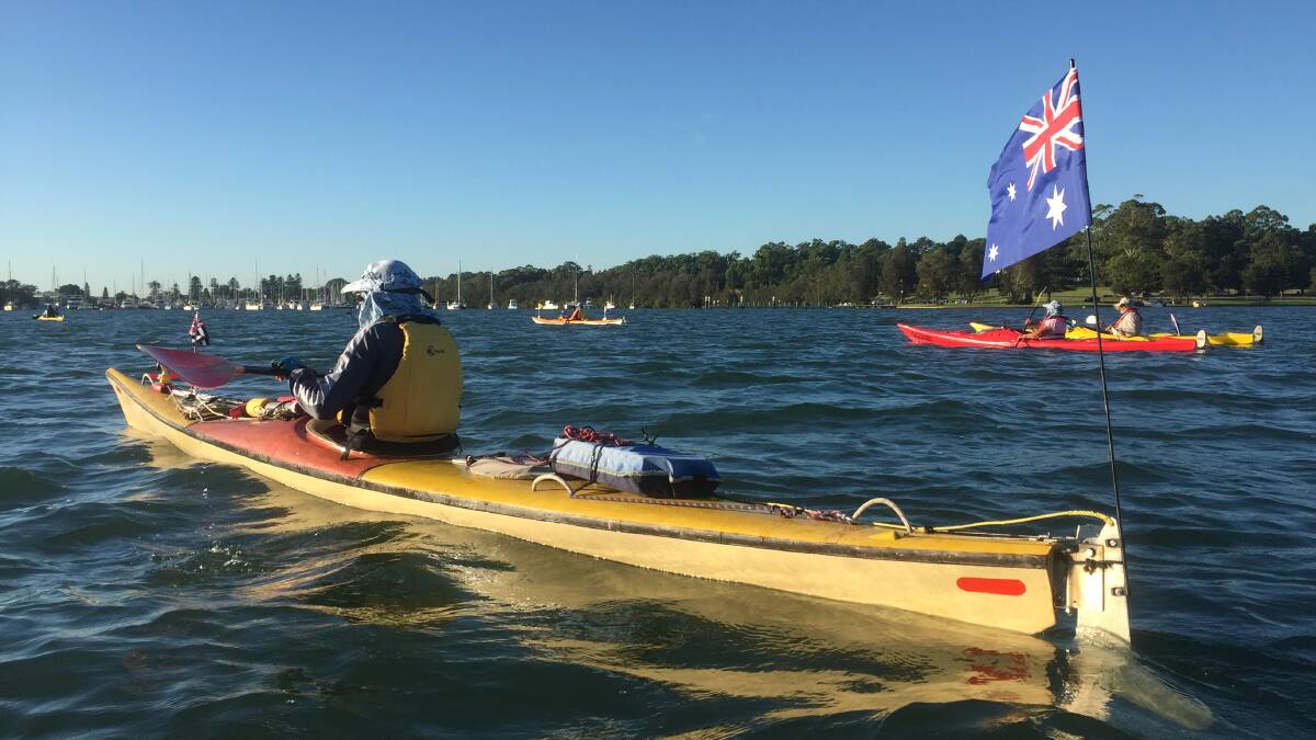 LAKE ADVENTURE: Tom Cordingley, with the Australian flag on his kayak's rudder, joins the flotilla paddling the length of the lake from north to south. Pictures: Scott Bevan