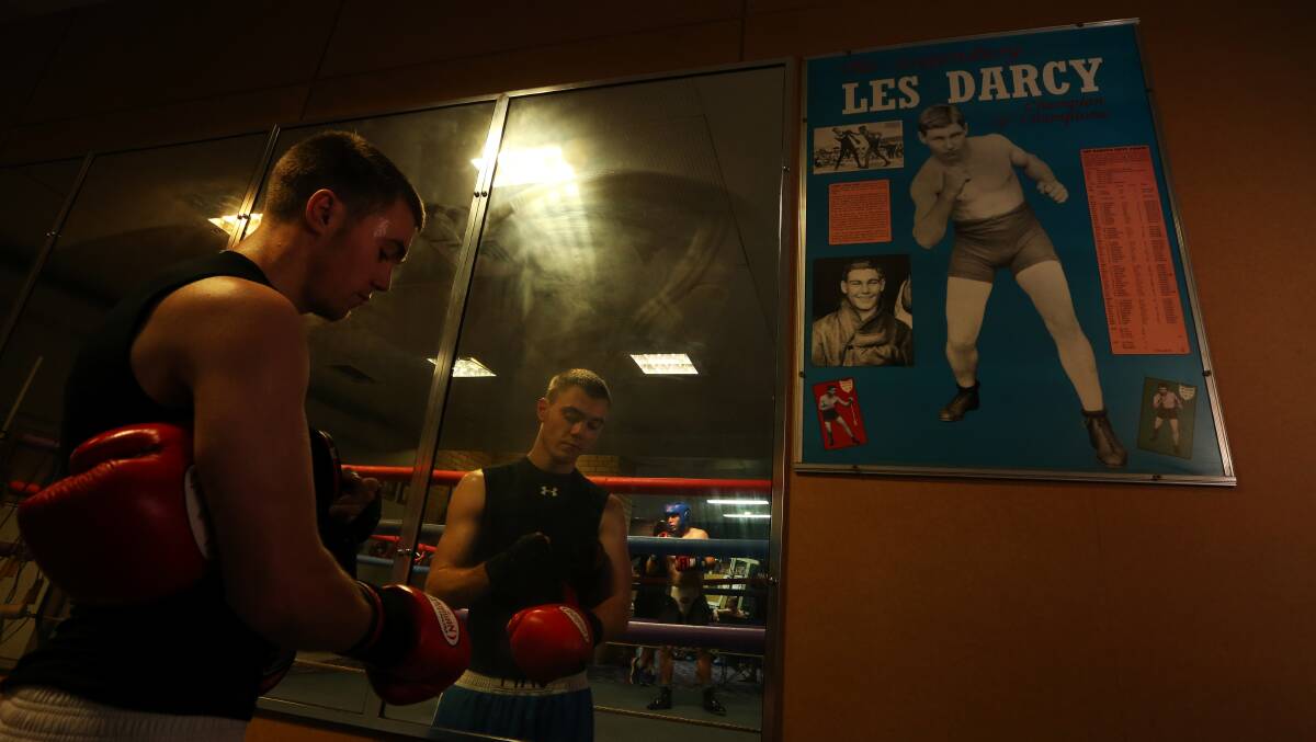 LEGEND: Maitland boxer Jesse Catt prepares to train, as the image of Les Darcy looks on from the poster. Picture: Simone De Peak
