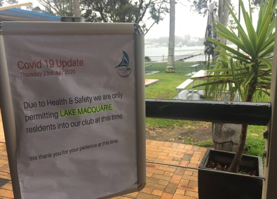 The sign at the door of Wangi RSL Club, with Lake Macquarie in the background.
