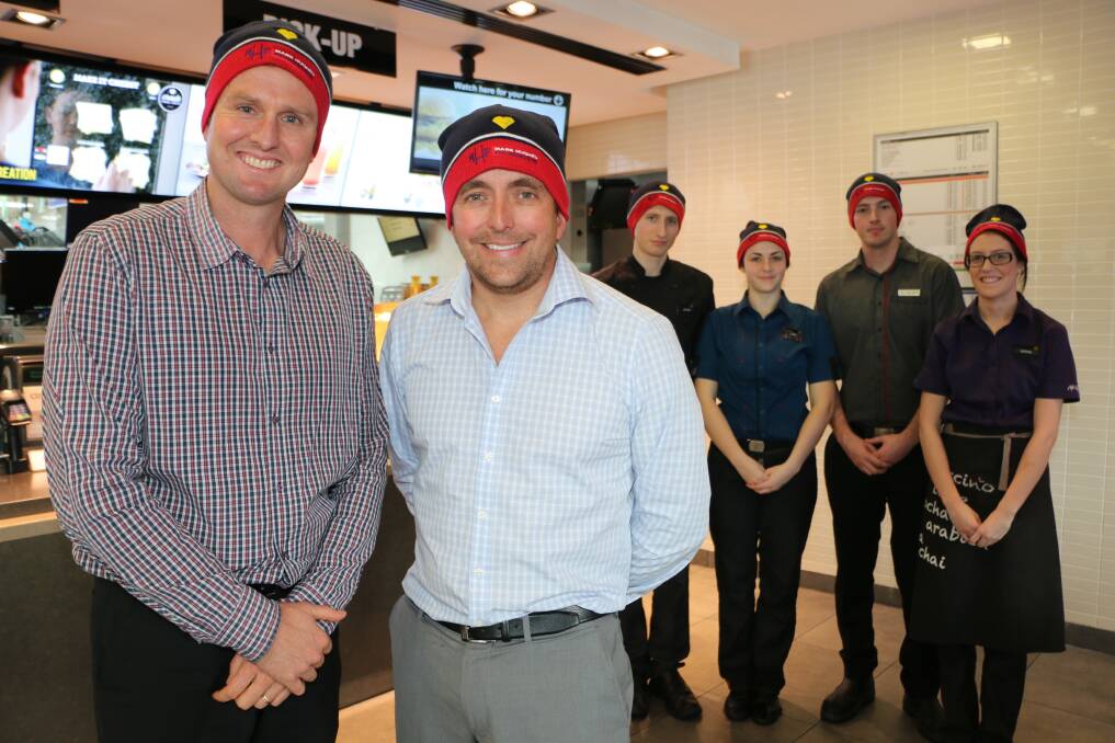 GOOD CAUSE: Mark Hughes and Adam Sherman don their beanies with some Toronto McDonald's crew members. Picture: Jamieson Murphy