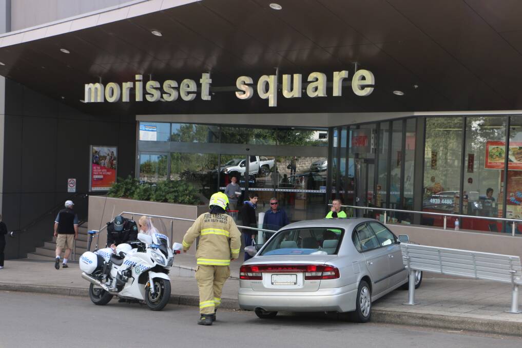 UP AND OVER: The Subaru crashed into the shopping centre wall close to the bus stop.  Pictures: David Stewart
