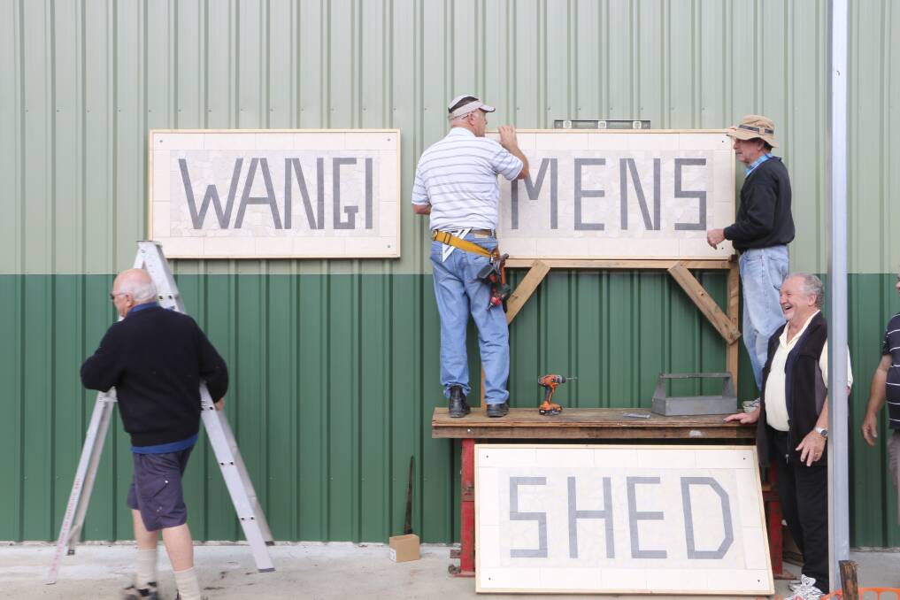 MILESTONE: Members erect the ceramic-tile mosaic signs crafted by Peter Cattalini. Picture: David Stewart