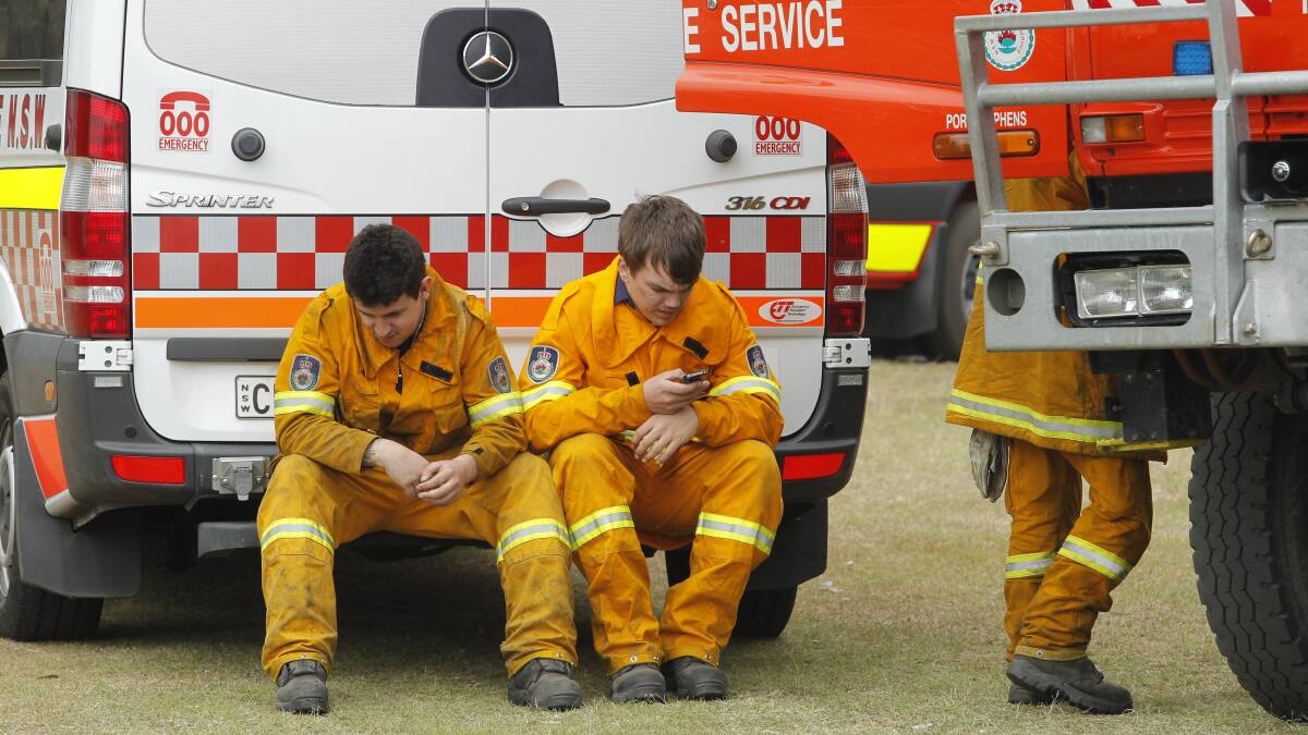Rural Fire Service crew resting at a command post at Finnan Park, Campvale. Photo: MAX MASON-HUBERS