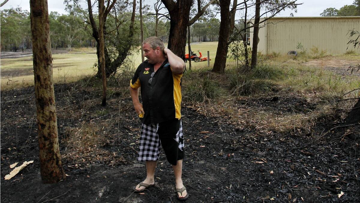 Heatherbrae / Raymond Terrace / Medowie bush fire. Photo shows Darren Watkins surveying how close the fire came to the shed behind his home on Medowie Road. Picture: Max Mason-Hubers 